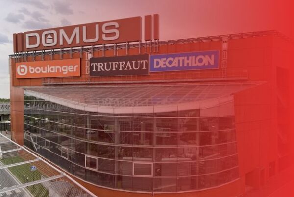 Exterior view of Domus shopping center in Rosny-sous-Bois, France, featuring its modern glass façade and main retail signage.