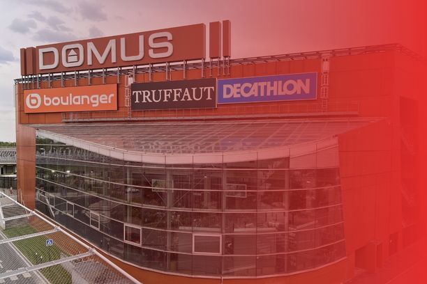 Vue extérieure du centre commercial Domus à Rosny-sous-Bois, en France, avec sa façade vitrée moderne et ses enseignes principales.