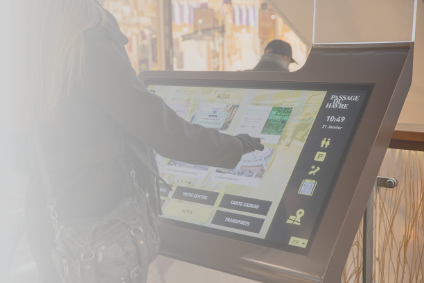 Person using an interactive wayfinding kiosk in a shopping center