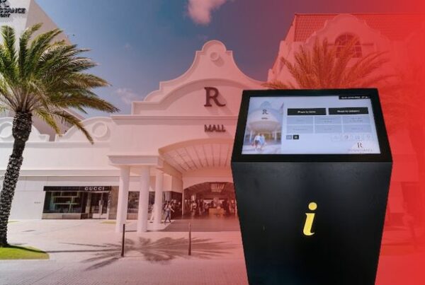 ViaDirect Marina model wayfinding kiosk in front of Renaissance Mall Aruba entrance, with Gucci storefront and palm trees visible in the background.