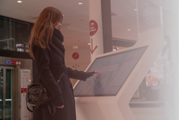 Woman using a ViaDirect interactive wayfinding kiosk in a shopping center