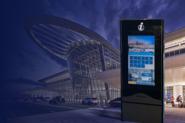 Interactive digital wayfinding kiosk installed at Orlando International Airport (MCO) by JCDecaux and ViaDirect, with the terminal building in the background.