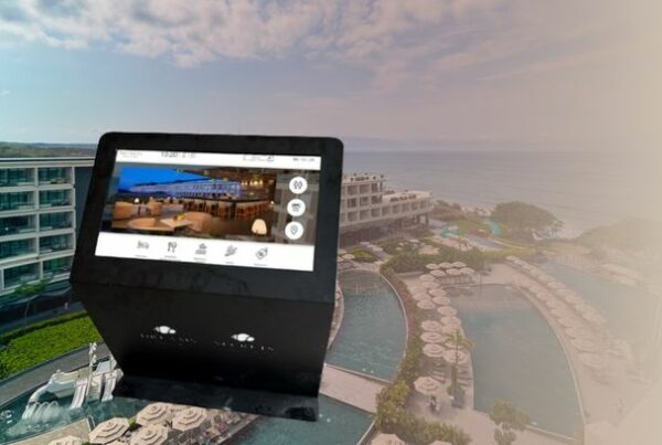 Kiosco interactivo de orientación digital de ViaDirect con pantalla táctil, ubicado en un mirador con vista al resort Secrets & Dreams Bahía Mita y el océano de fondo.