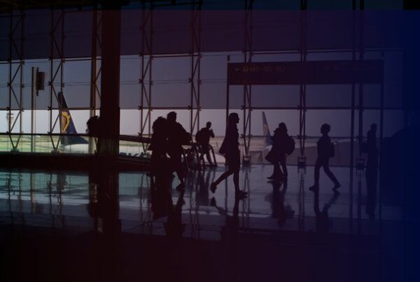 Passengers walking through a large airport terminal, illustrating the challenges of navigation and wayfinding in complex transportation hubs.